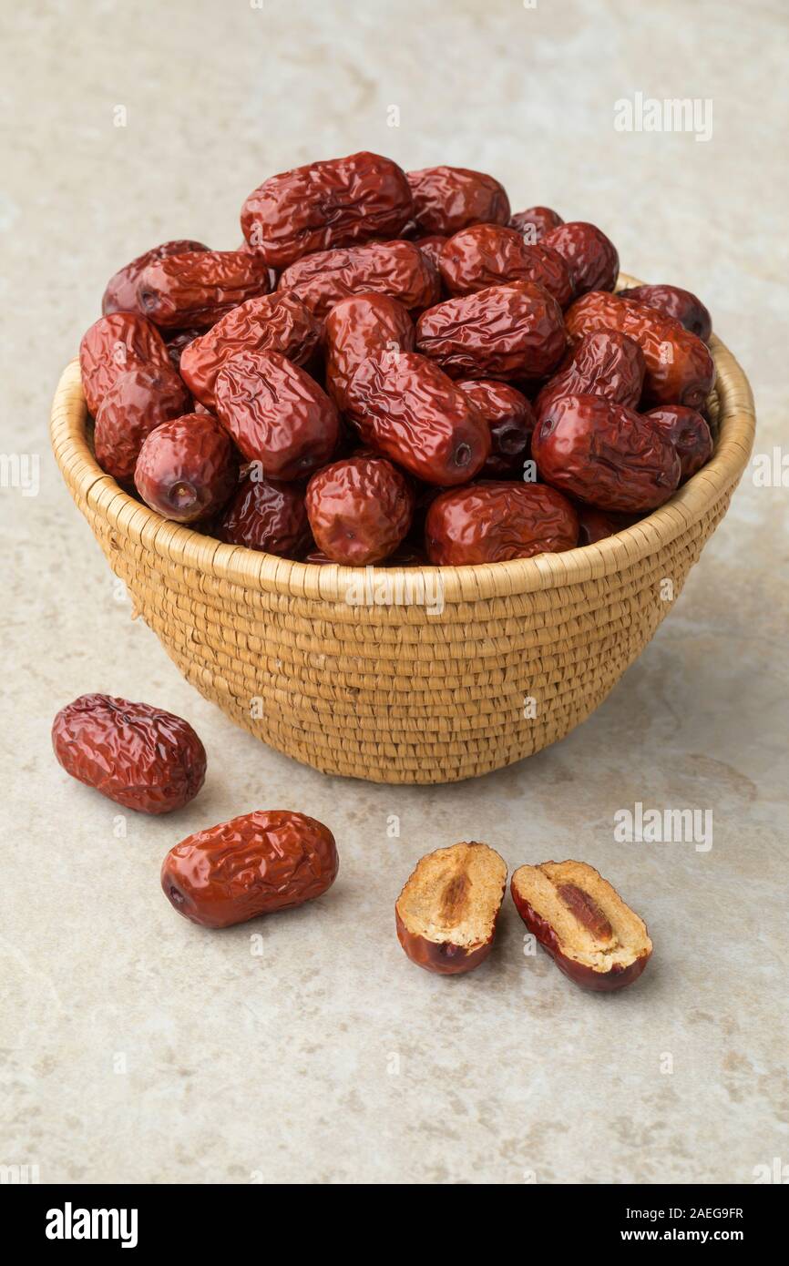 Basket with whole dried Chinese red dates and a halved one with kernel