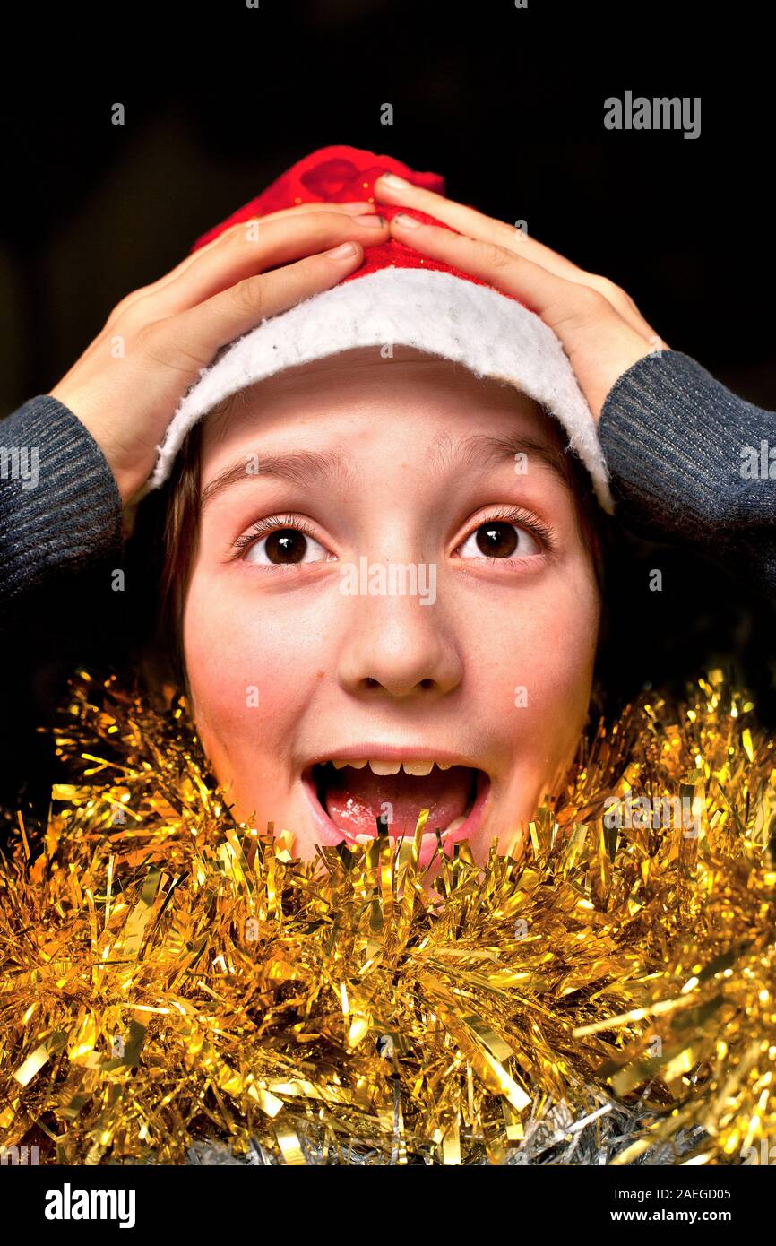 Boy wearing Christmas hat, looking overjoyed Stock Photo Alamy