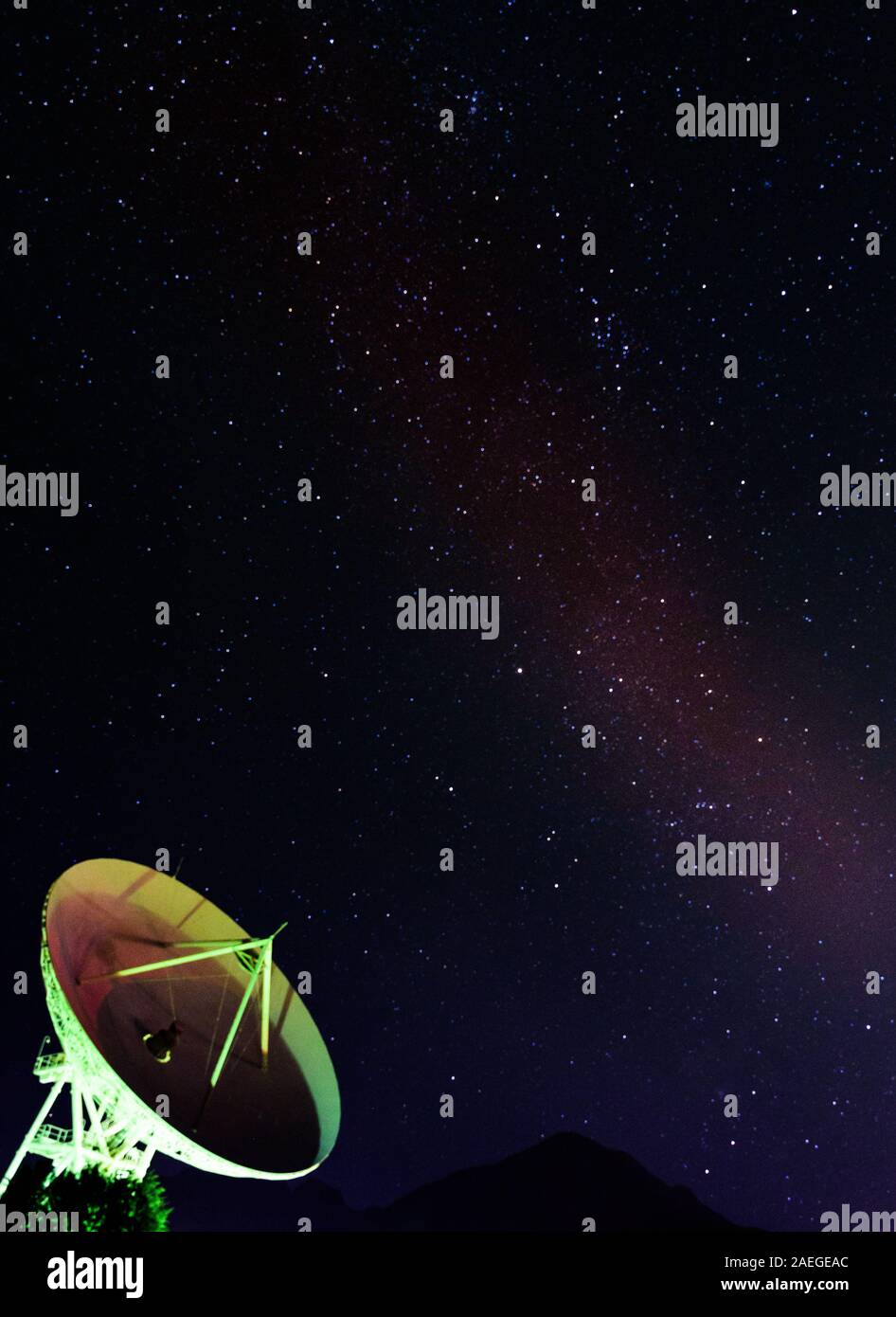 Satellite dish under the starry sky of the Milky Way, vertical night