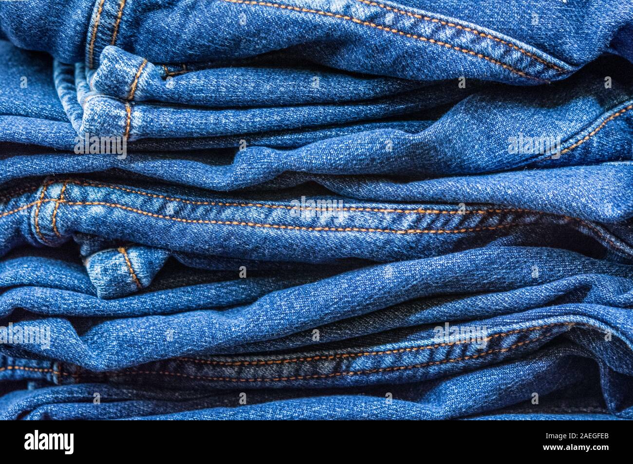 Jeans stacked as a background Stock Photo - Alamy