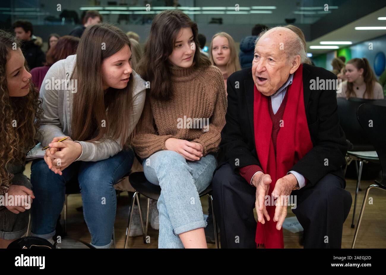 Stuttgart, Germany. 09th Dec, 2019. Salomon "Sally" Perel (r), NS survivor,  sits at the Dillmann-Gymnasium in Stuttgart before a reading next to  schoolgirls. Perel survived National Socialism by keeping his Jewish  identity