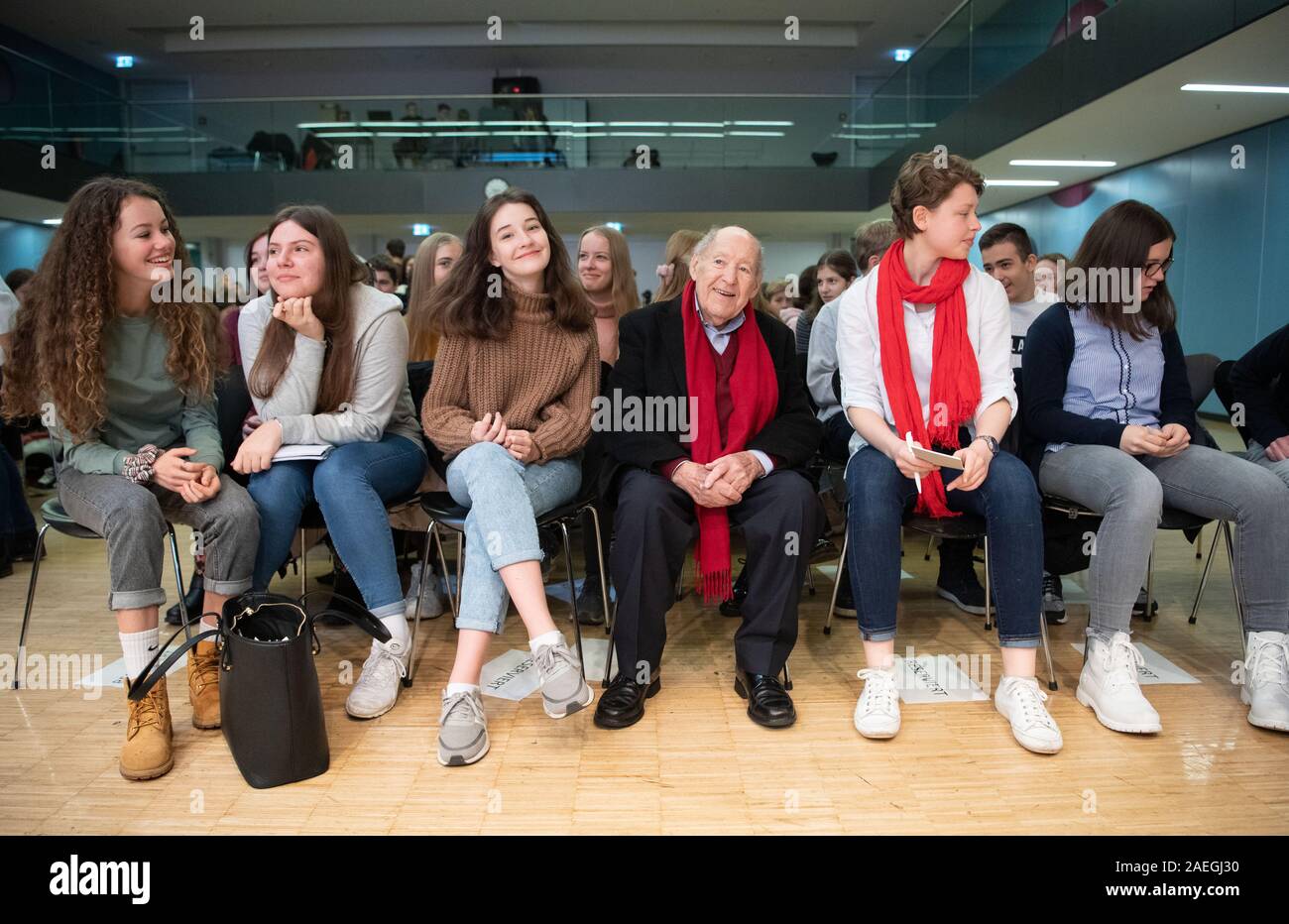 Stuttgart, Germany. 09th Dec, 2019. Salomon "Sally" Perel (3rd from right),  NS survivor, sits at the Dillmann-Gymnasium in Stuttgart in front of a  reading between schoolgirls. Perel survived National Socialism by keeping