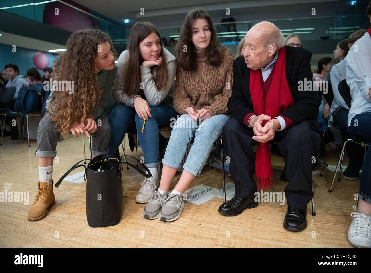 Stuttgart, Germany. 09th Dec, 2019. Salomon "Sally" Perel (r), NS survivor,  sits at the Dillmann-Gymnasium in Stuttgart before a reading next to  schoolgirls. Perel survived National Socialism by keeping his Jewish  identity