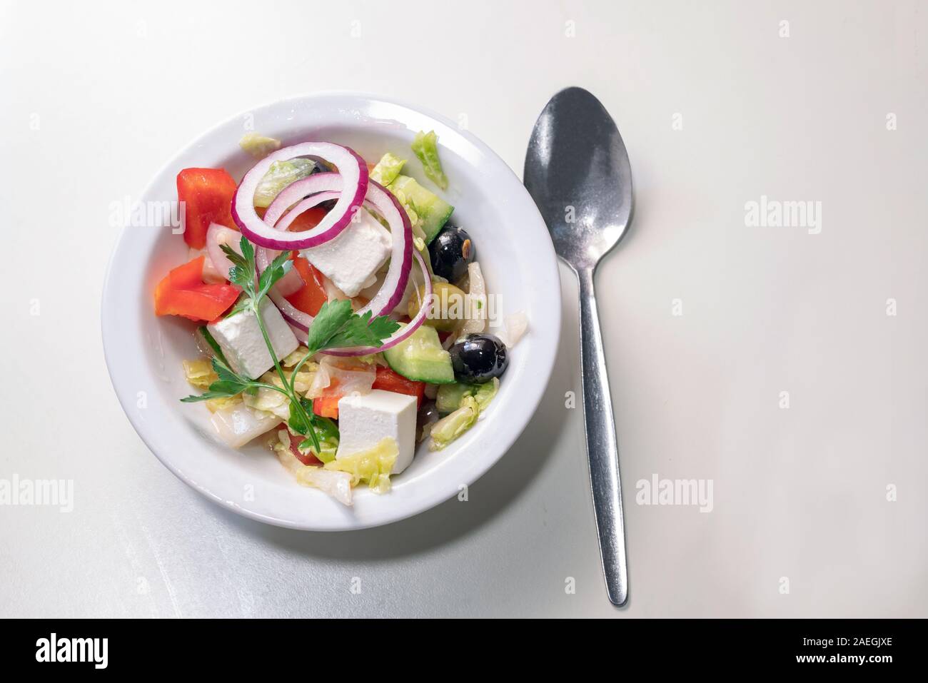 Greek sald : olives, onion, tomatoes , cucumbers and feta cheese with spoon Stock Photo