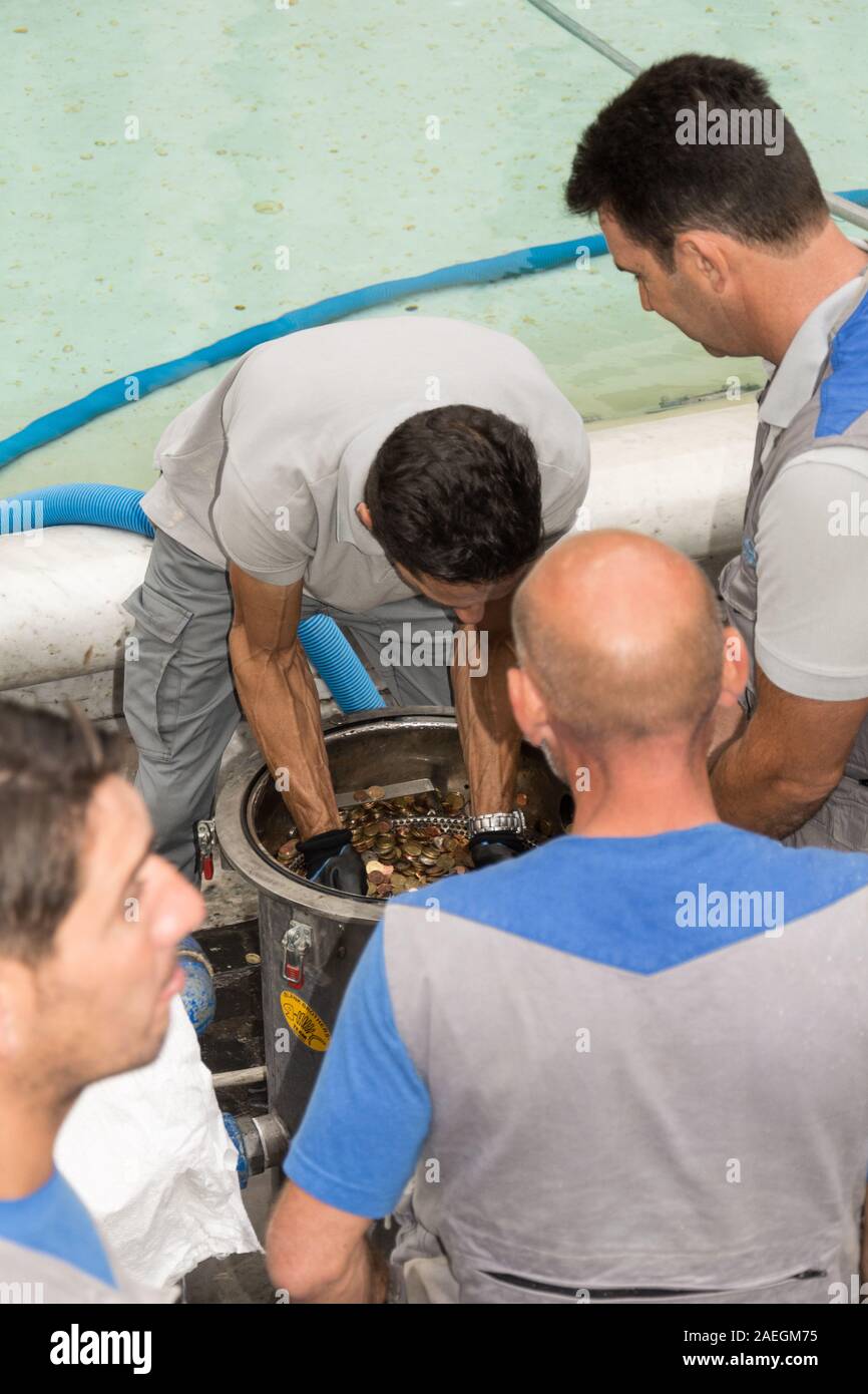 Rome, Italy - Oct 05, 2018: Workers rake coins from the famous fountain of Trevi Stock Photo