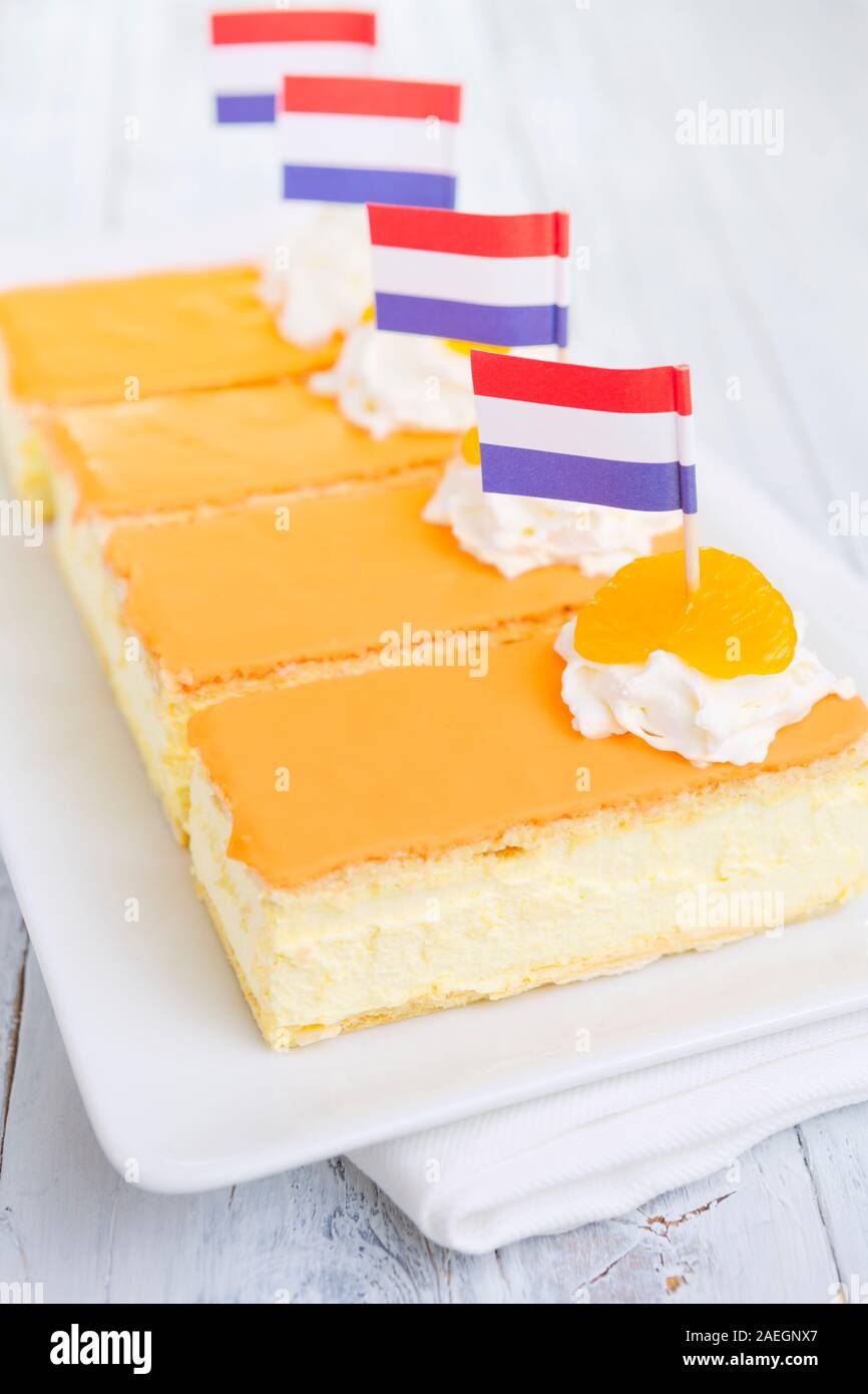 An orange tompouce, traditional Dutch pastry, on a white background. The orange icing on the tompouce is typical for King's Day ('Kongingsdag') on Apr Stock Photo