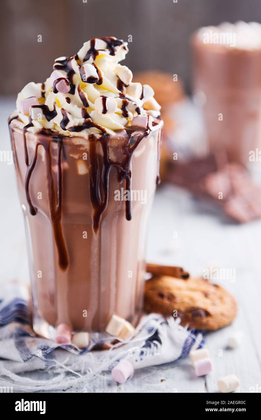 A messy glass with hot chocolate, whipped cream, marshmallows and ...