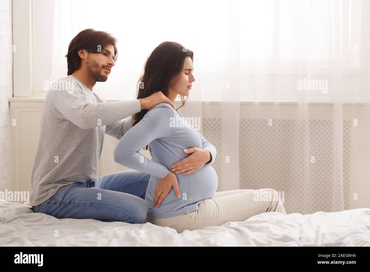 Caring husband massaging shoulders of his pregnant wife Stock Photo