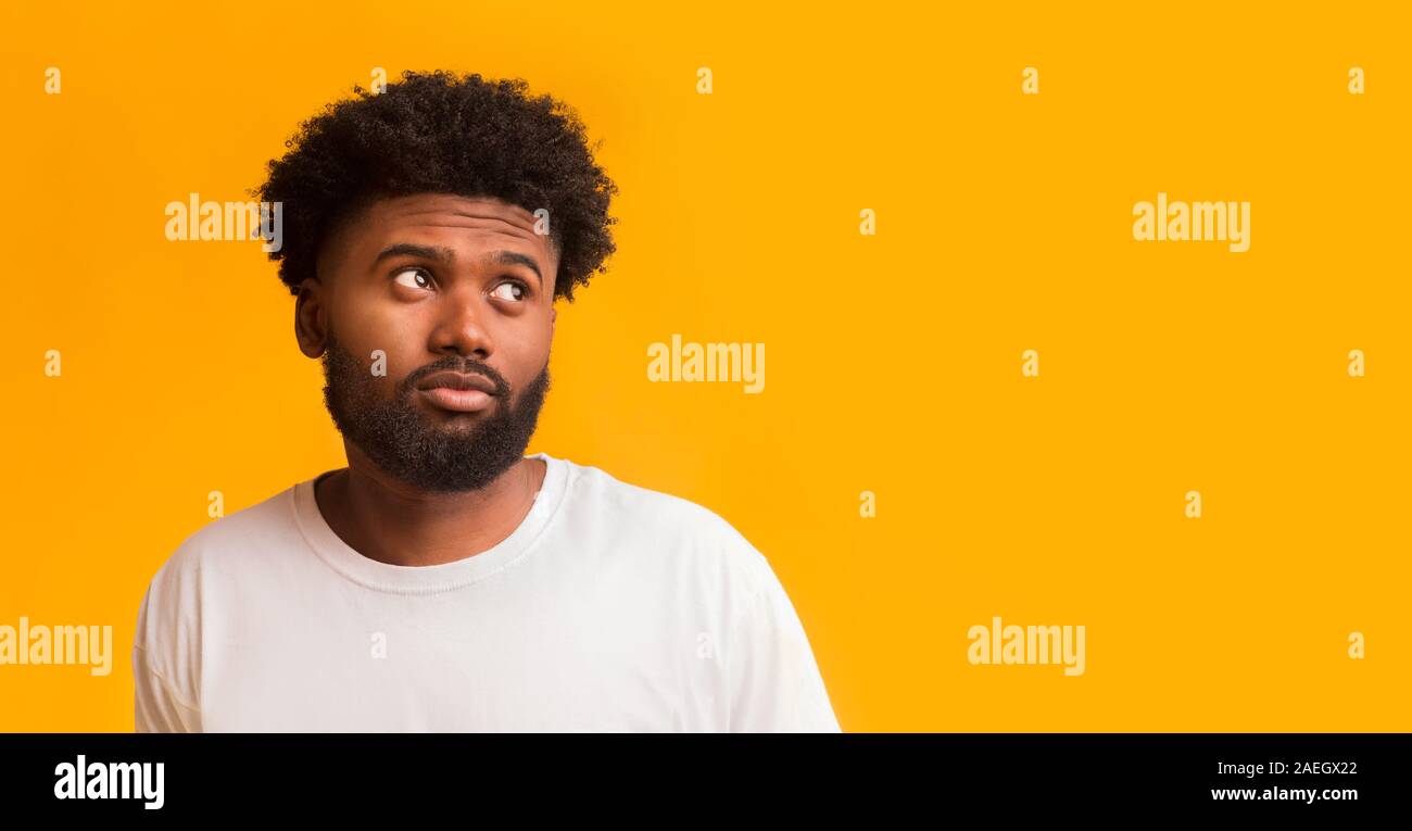 Doubtful young man looking at free space Stock Photo