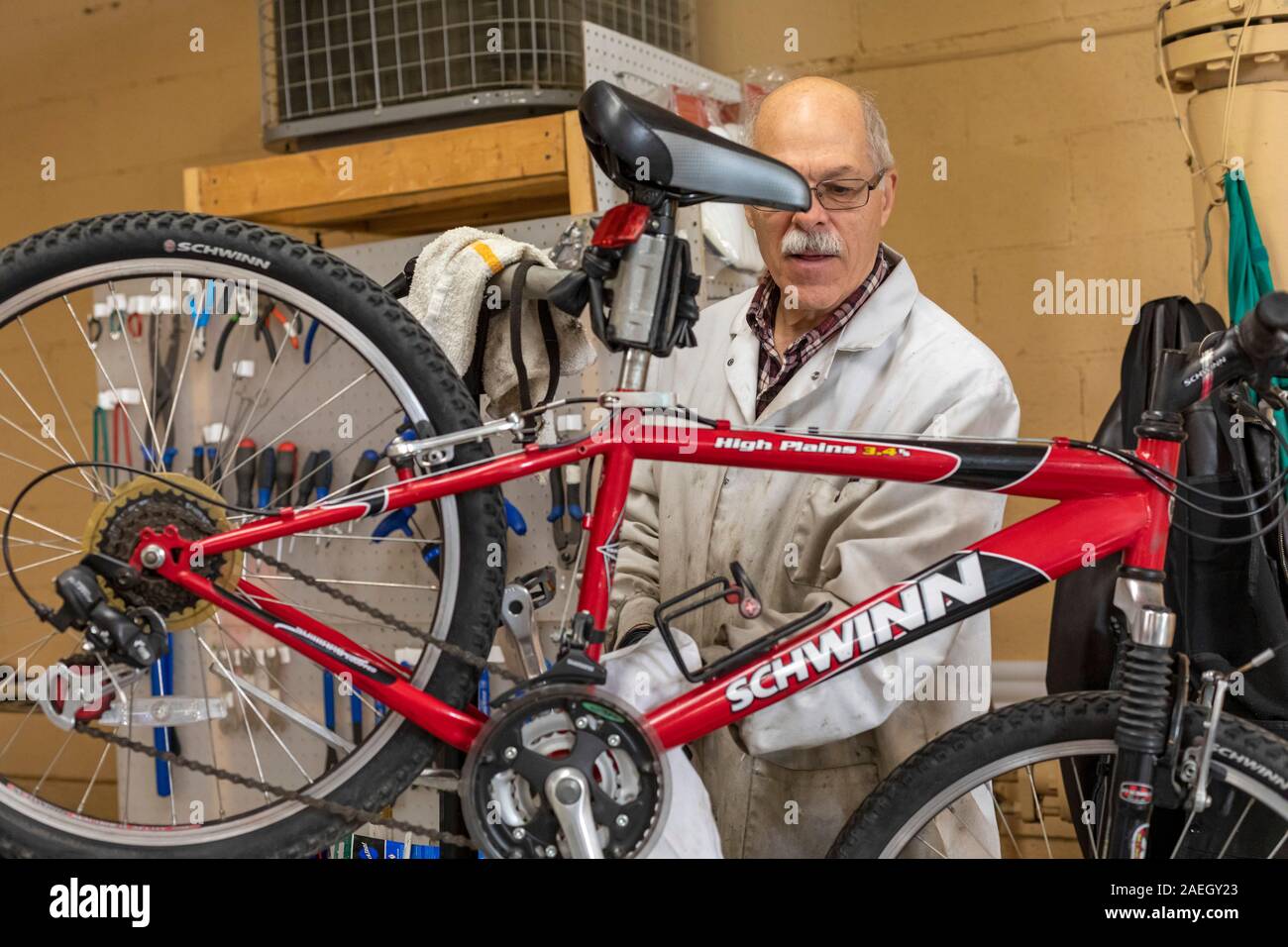 Detroit, Michigan - A man cleans a bicycle, one of thousands of used bikes that Free Bikes 4 Kidz collects each year, repairs, and gives away to child Stock Photo