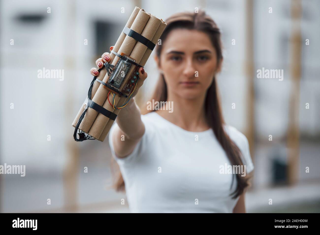 Digital elements. Showing time bomb. Young woman holding dangerous explosive weapon in hand Stock Photo