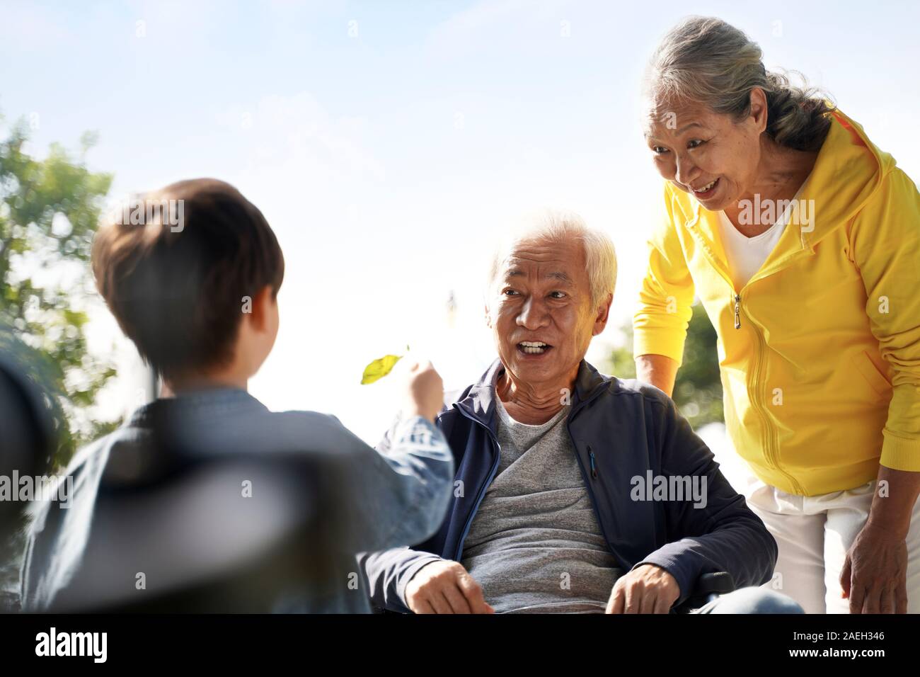 asian grandfather grandmother and grandson having fun outdoors in park Stock Photo