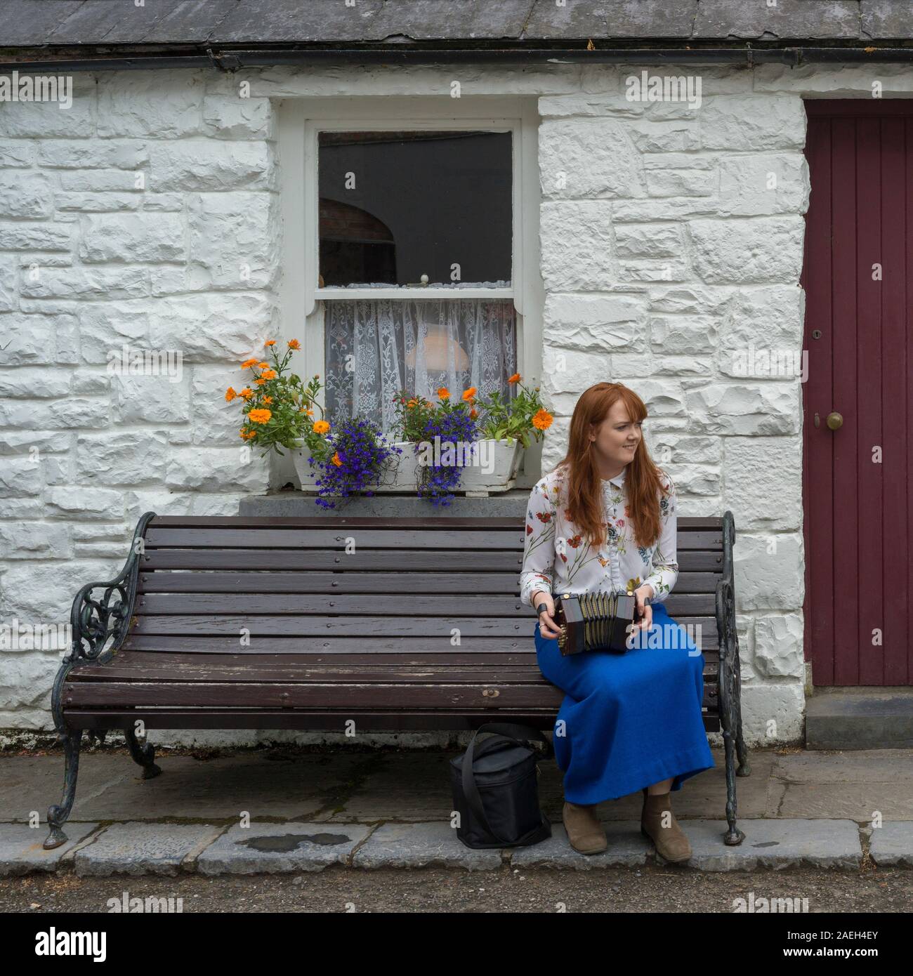 Woman playing Squeezebox outside store, Bunratty, County Clare, Republic of Ireland Stock Photo