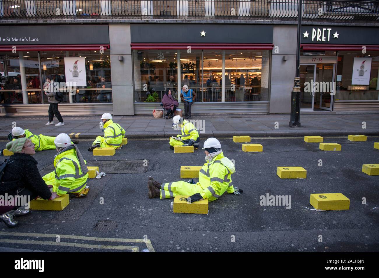 Cranbourn Street, London, UK. 9th December 2019. Extinction Rebellion protesters glue themselves onto the road in Cranbourn Street, Leicester Square, and block the road with a truck to bring attention to London’s air pollution. Credit: Malcolm Park/Alamy Live News. Stock Photo