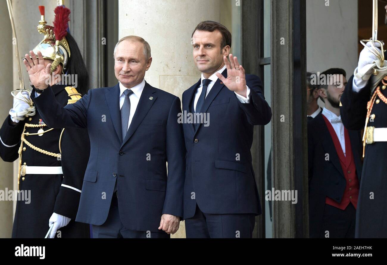Paris, France. 09 December, 2019. Russian President Vladimir Putin, left, and French President Emmanuel Macron wave as they enter the Elysee Palace December 9, 2019 in Paris, France. Putin in in Paris for the Normandy Four Summit in an effort to find an end to the war in Ukraine. Credit: Alexei Nikolsky/Kremlin Pool/Alamy Live News Stock Photo