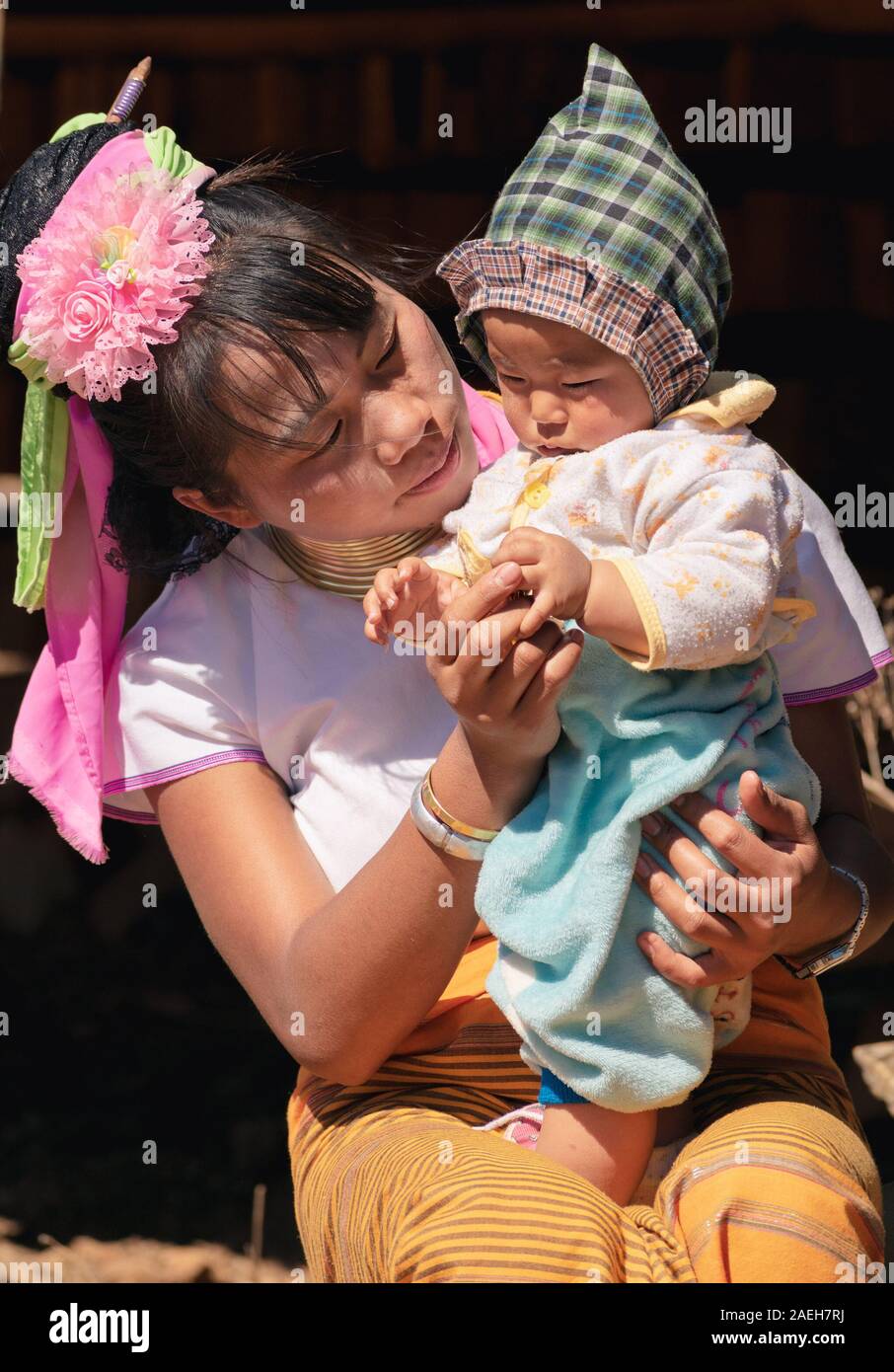 Portrait of young mother from Kayan tribe wearing traditional outfit with her baby in Pan Pet village, Loikaw, Myanmar. Stock Photo