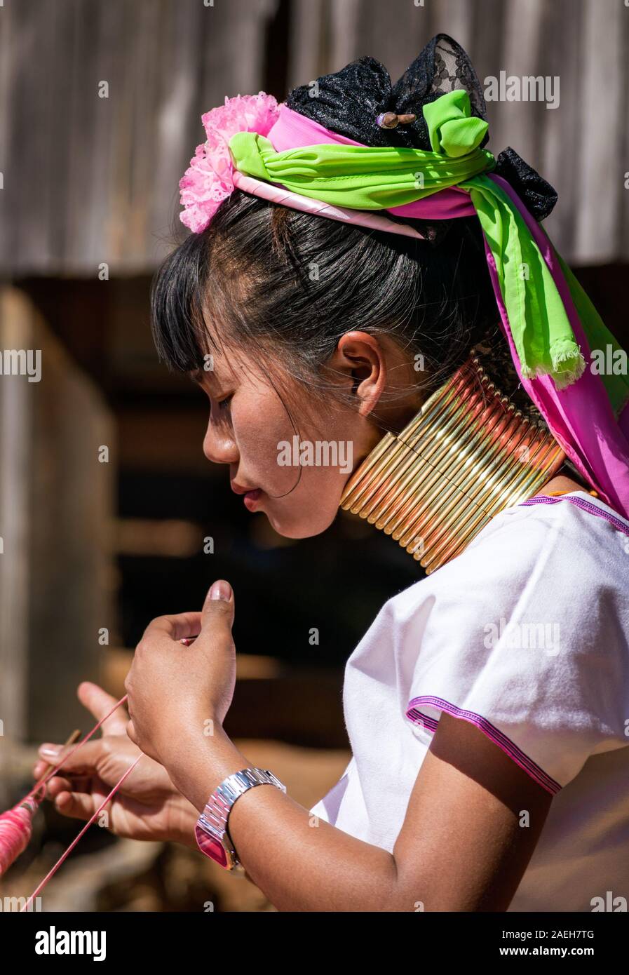 Portrait of a young woman from Kayan tribe wearing traditional outfit (and a modern watch) and brass necklace. Pan Pet, Loikaw, Myanmar. Stock Photo