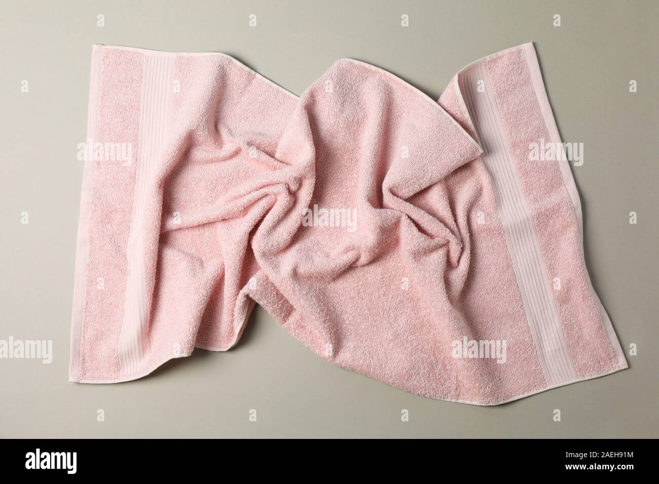 Crumpled pink towel on grey background, top view Stock Photo