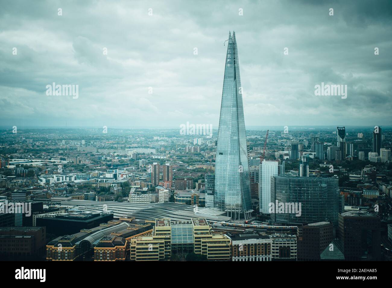 Aerial view of London with The Shard skyscraper and Thames river at sunset with grey clouds in the sky. Stock Photo