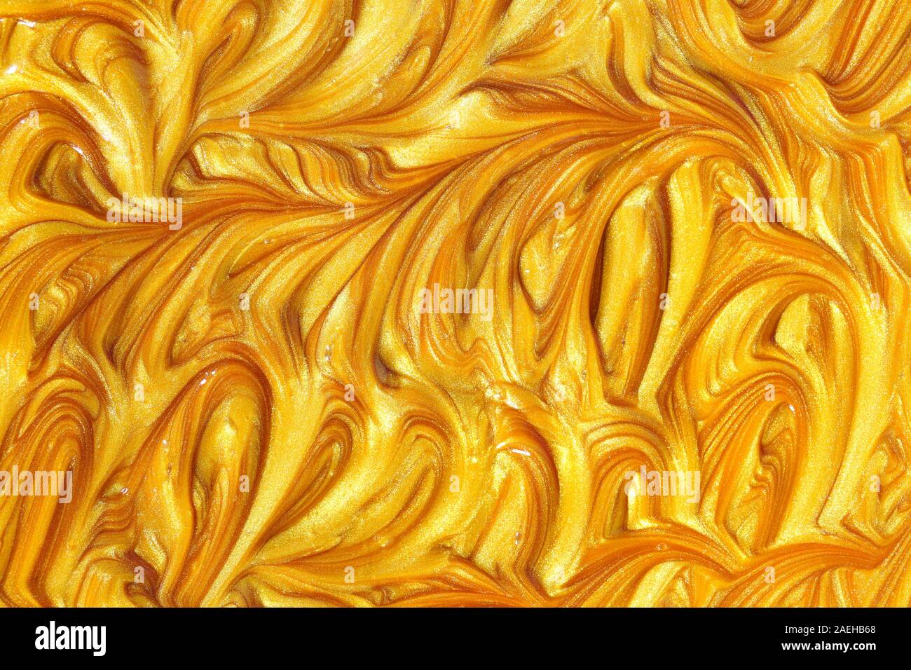 Close up liquid luxury gold metallic glitter paint swirls to make an  abstract textured background Stock Photo - Alamy