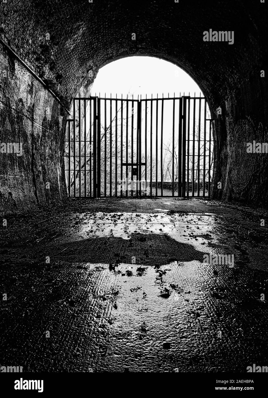 Iron gate at the end of a tunnel Stock Photo