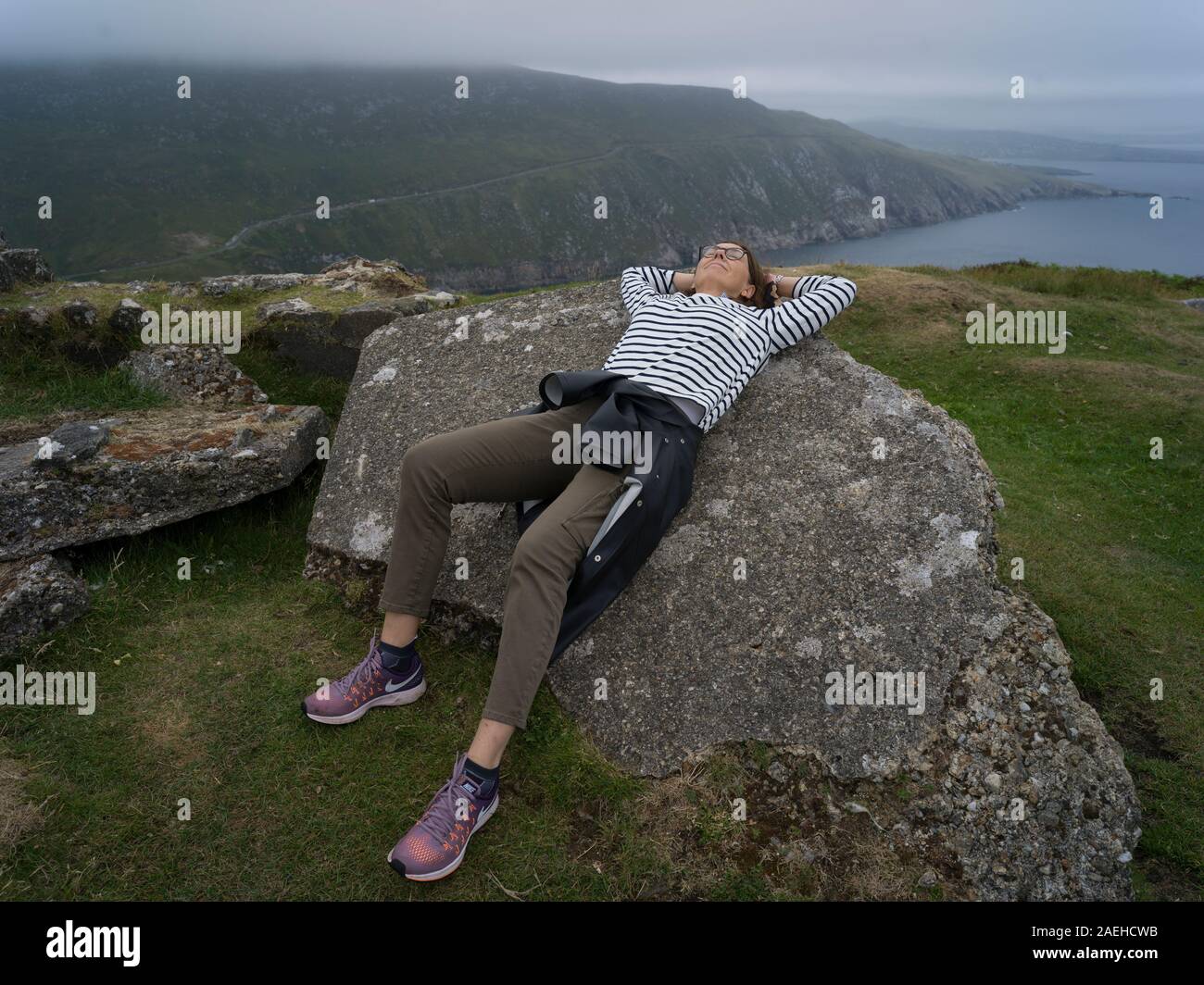 Resting Back Woman resting back on a rock at Achill Island, County Mayo, Ireland ...