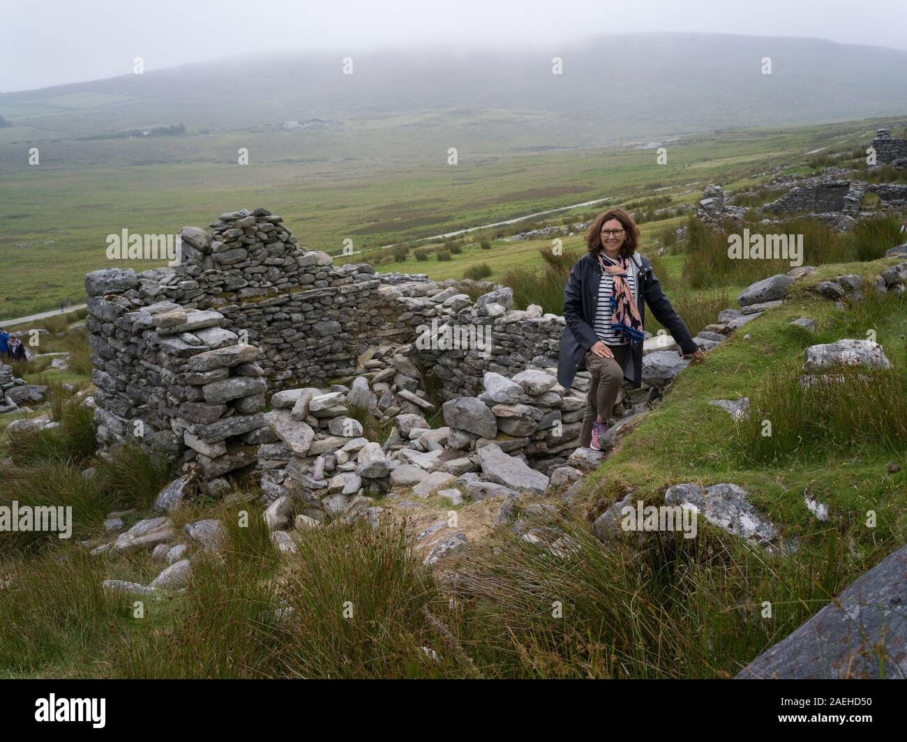 Women standing on the ruins of deserted village, Achill Island, County Mayo, Ireland Stock Photo
