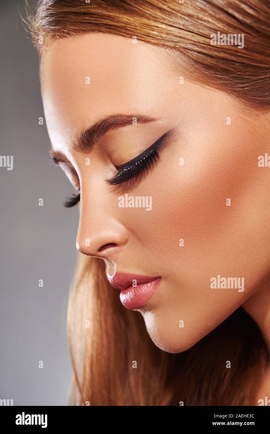 Beautiful fashion luxury makeup, false long eyelashes, perfect skin facial make-up. Side view Stock Photo