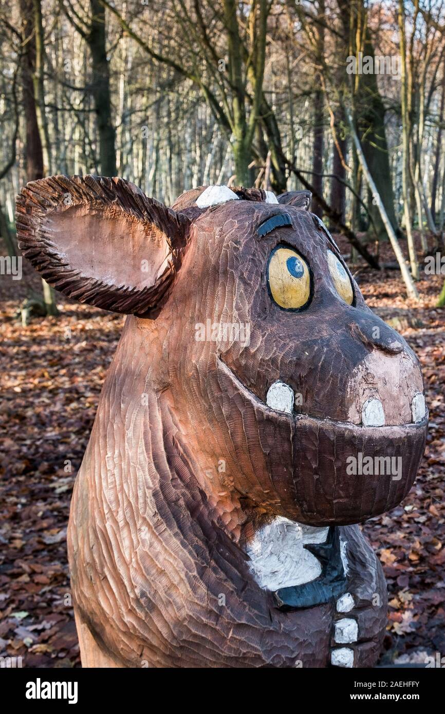 A wooden carved statue of a Baby Gruffalo in an autumnal Thorndon Park North in Brentwood in Essex. Stock Photo