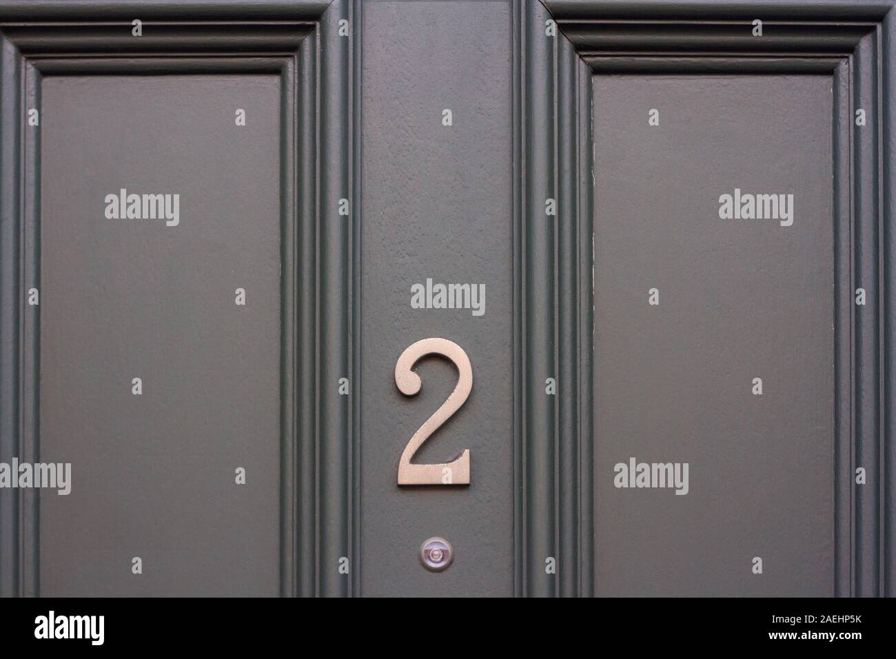House number 2 on an elegant and gracefully carved wooden front door Stock Photo