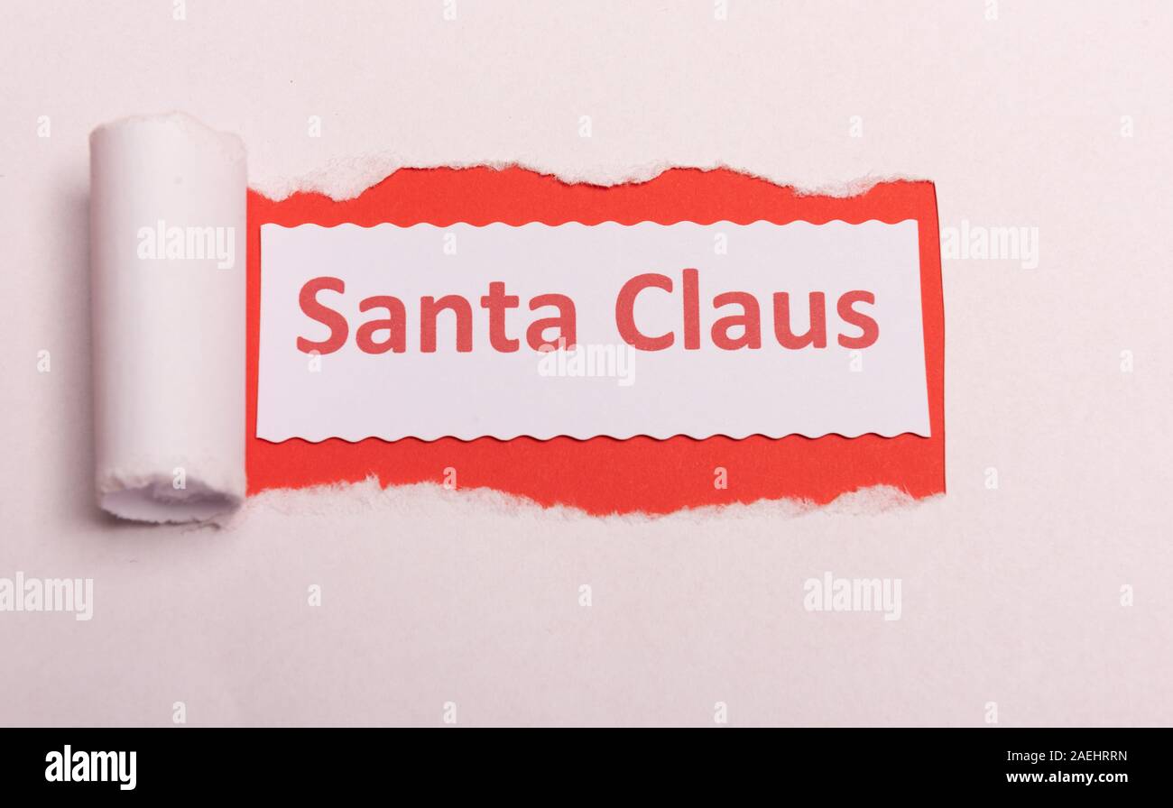 White torn paper with Santa Claus text with red background color. Hidden message. Secret. Copy space Stock Photo