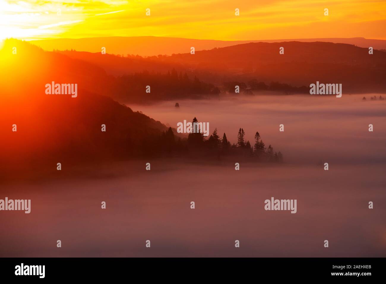 Valley mist over Lake Windermere from Todd Crag in the Lake District, UK at sunrise. Stock Photo