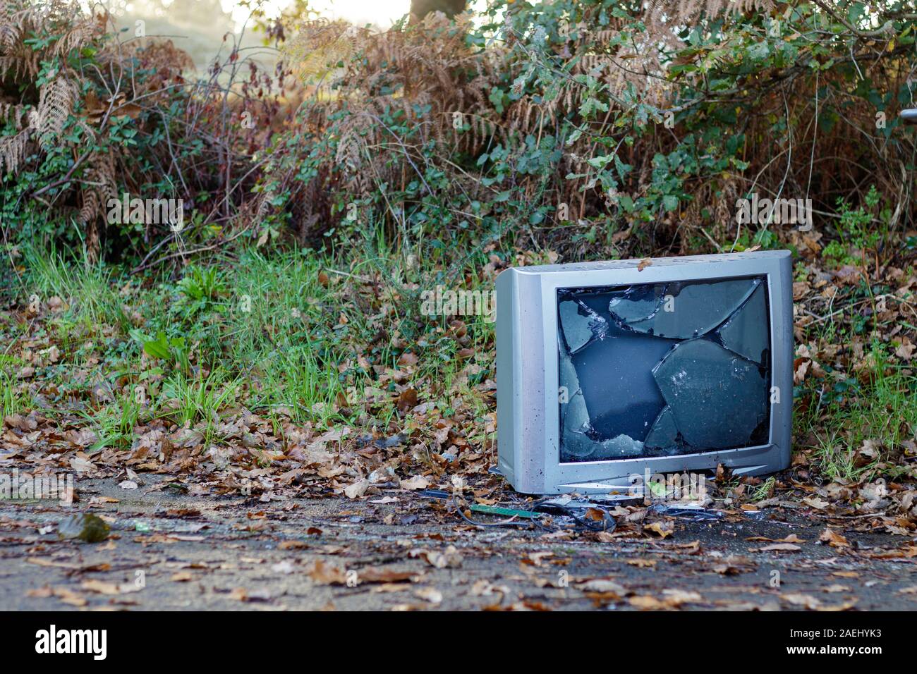 Coruna / Spain - December 08 2019: Old gray CRT television smashed and dumped at the side of the road in Coruna Spain Stock Photo