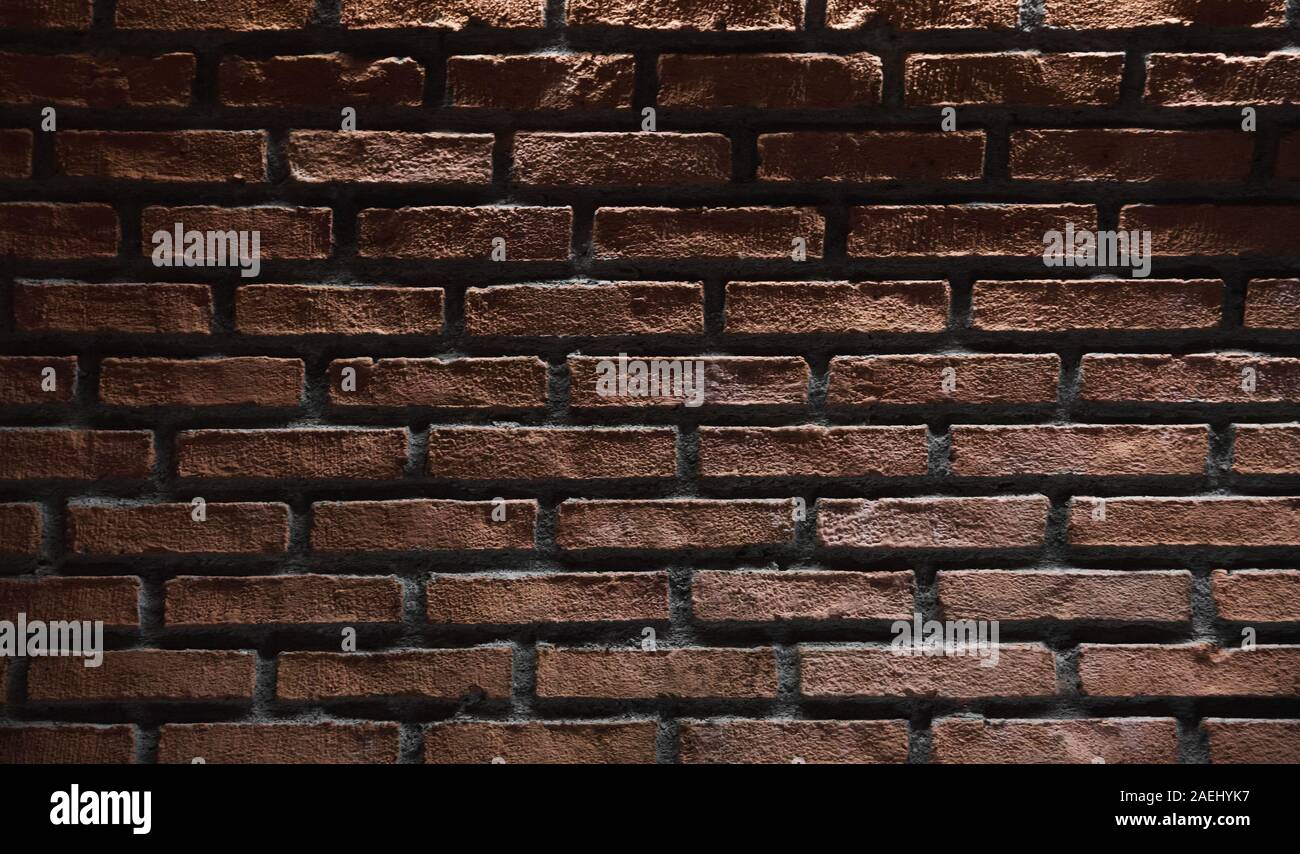 Dark red brick wall with top illumination effect. Background photo texture Stock Photo