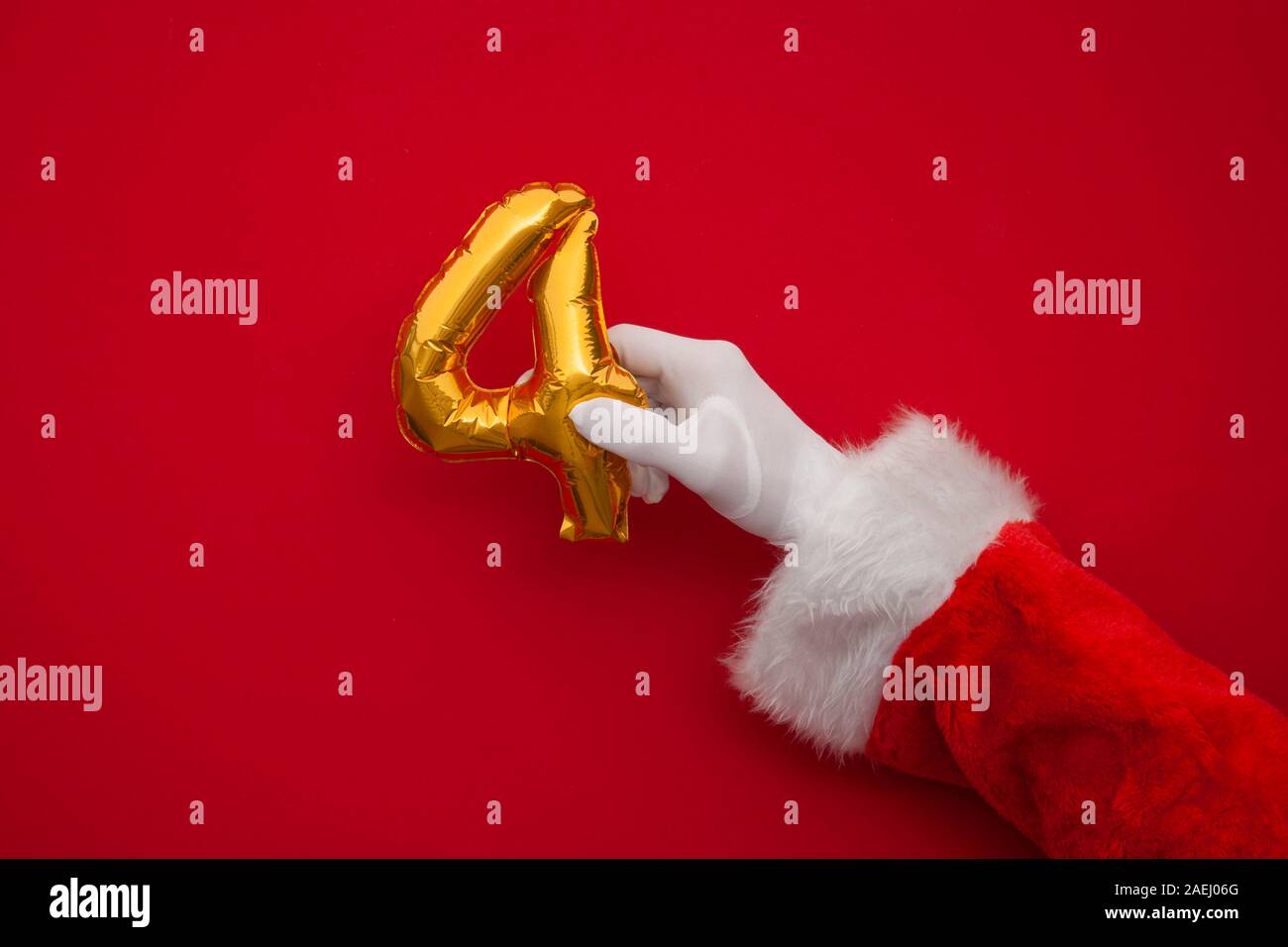 12 days of christmas. Santa hands holding 4th day balloon on red background Stock Photo