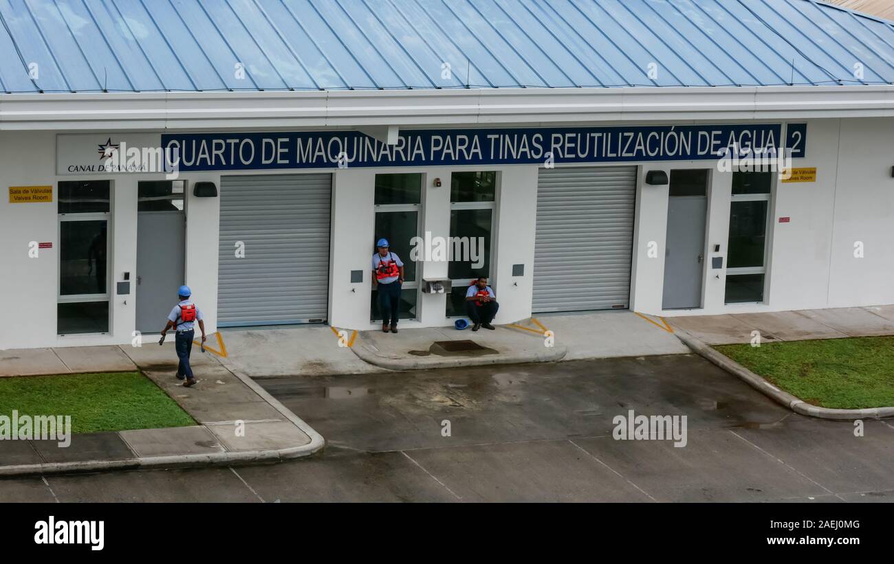 Panamanian workers resting in front of the Machine   Building (Cuarto de Maquinaria) in Agua clara locks. Stock Photo