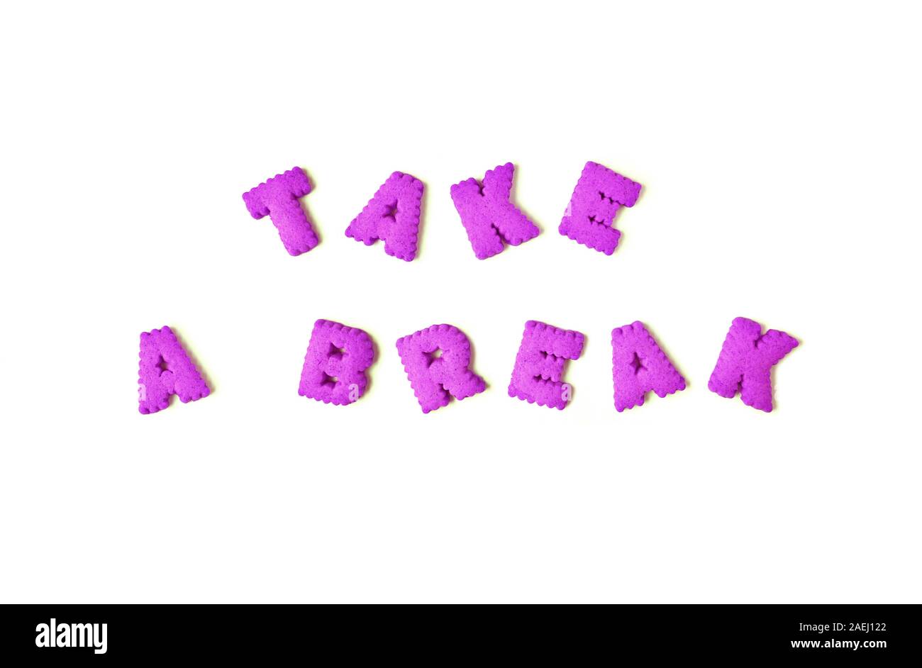 The word TAKE A BREAK spelled with vivid pink colored alphabet shaped cookies on the white background Stock Photo