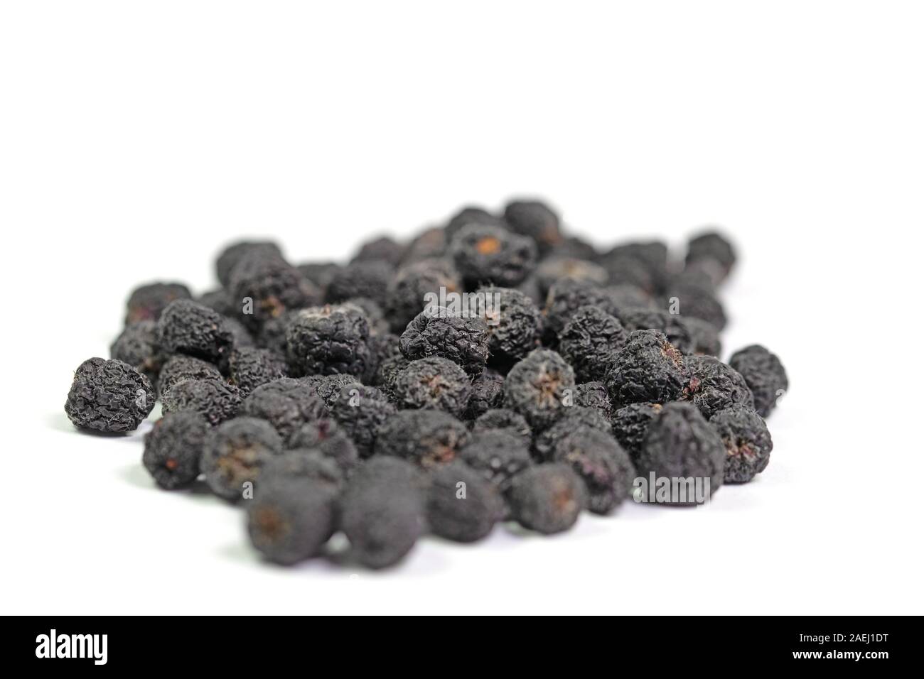 Dried Aronia berries, Aronia melanocarpa, in front of white background Stock Photo