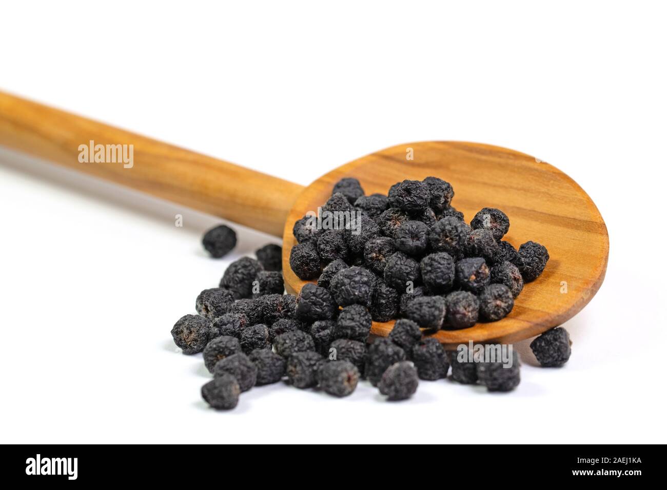 Dried Aronia berries, Aronia melanocarpa, on a wooden spoon Stock Photo