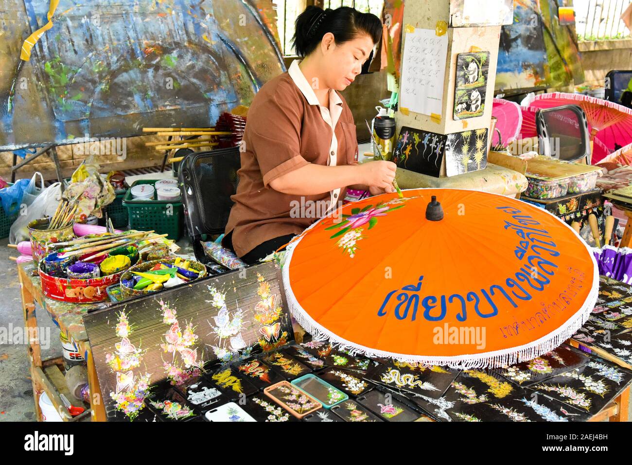 Thai woman Painting a paper umbrella at Bo Sang Paper Umbrella Village , Northern Thailand Stock Photo