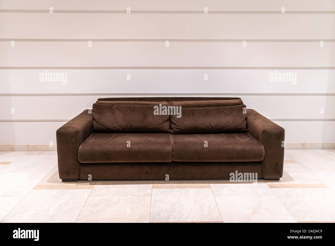 Modern brown textile couch with light wall and copy space Stock Photo
