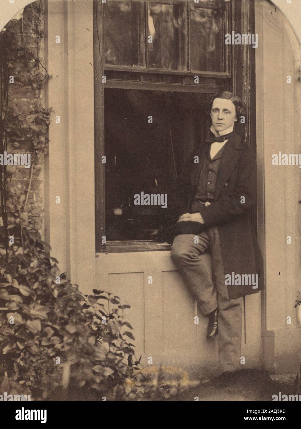 Lewis Carroll, Lewis Carroll Seated on a Windowsill of the Old Rectory at Croft, Darlington, Yorkshire, 1857 Lewis Carroll Seated on a Windowsill of the Old Rectory at Croft, Darlington, Yorkshire; 1857date Stock Photo