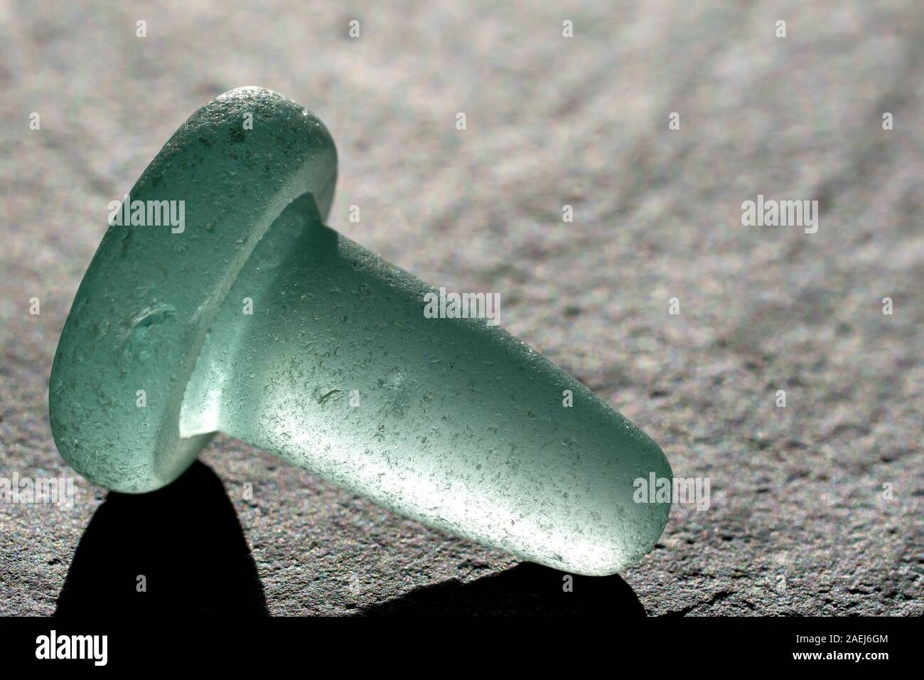 Close up still life of an old fashioned, pale green, backlit glass bottle stopper Stock Photo