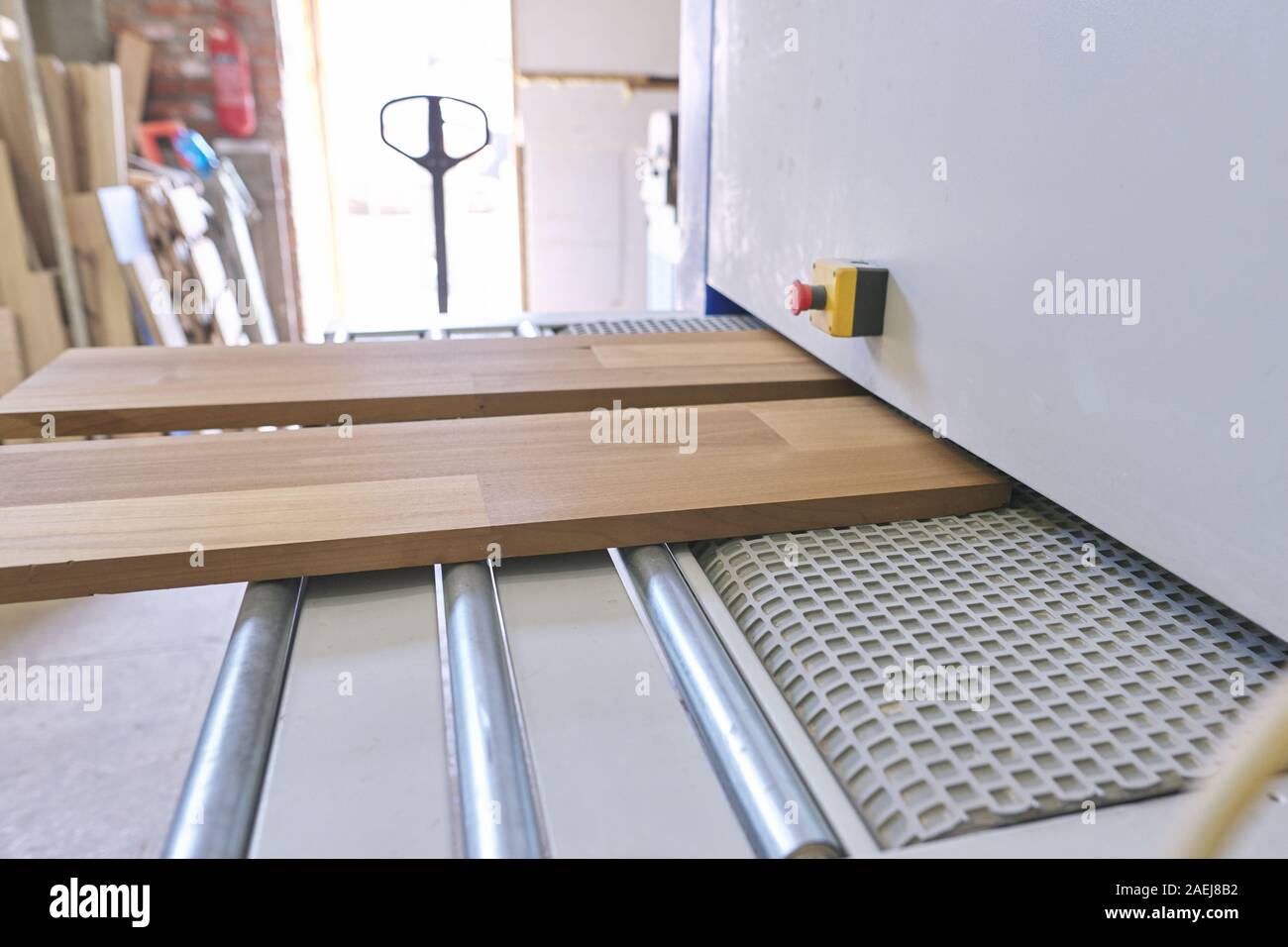 Furniture carpenters working automated sanding machine for