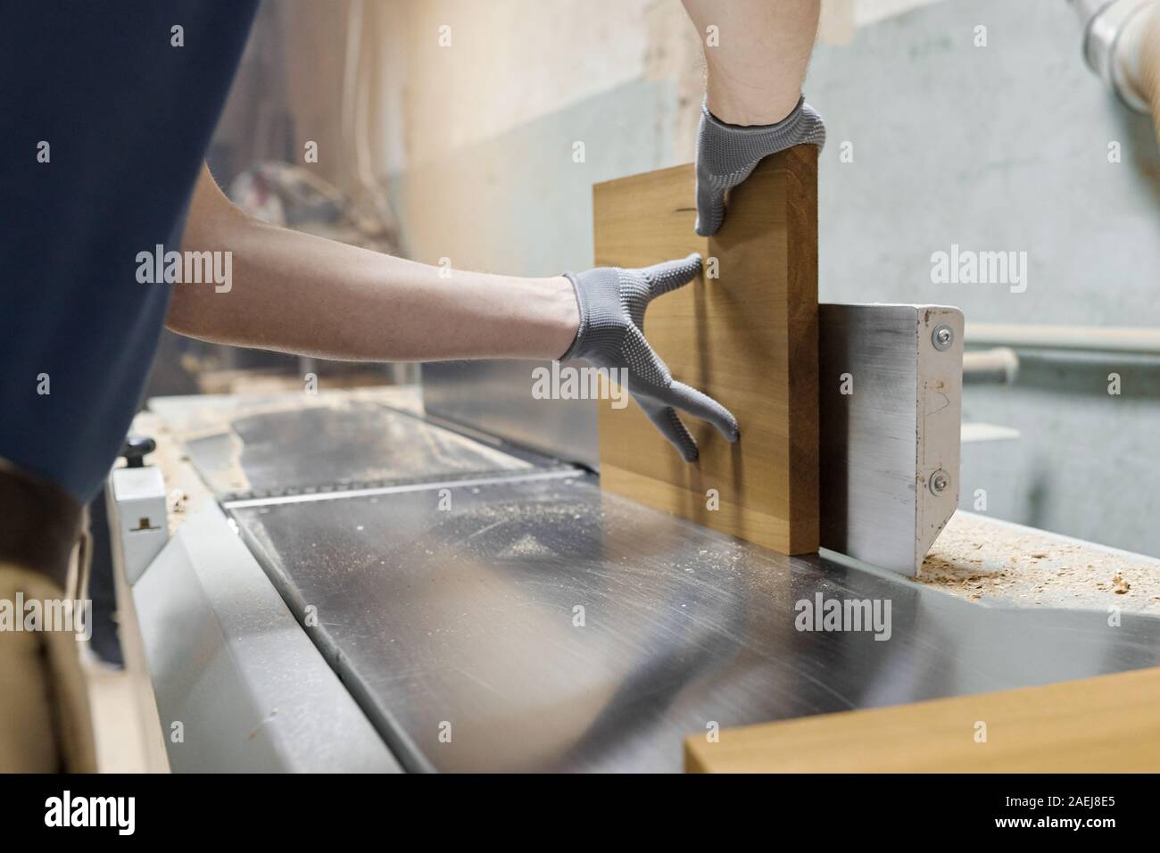 Hands of carpenter men working with wood boards on sanding machine ...