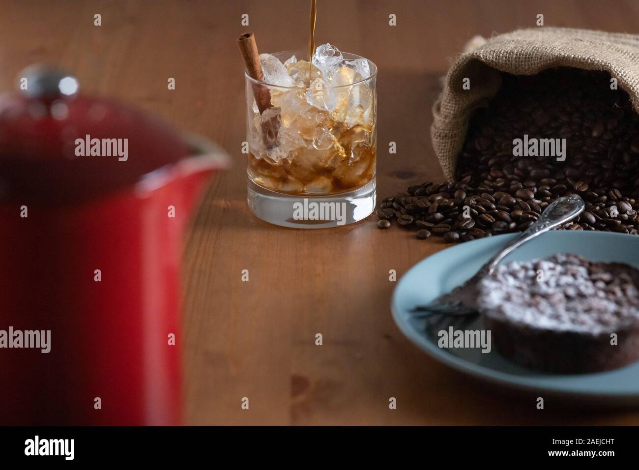 Ice coffee in glass mug with milk and cinnamon on wooden table in the  garden Stock Photo - Alamy