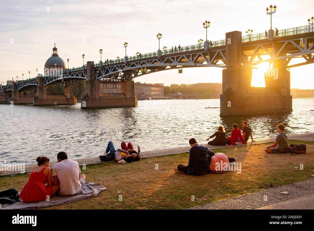 Relaxing down by Henri Martin promenade / Quai Lucien Lombard / Garonne riverbank and Pont Saint-Pierre / Saint Pierre Bridge, Toulouse, France Stock Photo