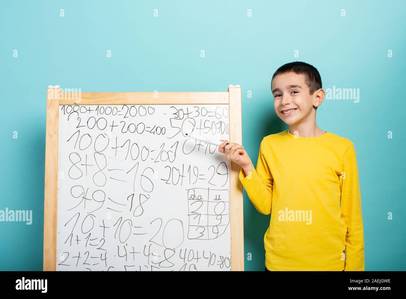 Child solves mathematical problem with abacus. Cyan background Stock Photo