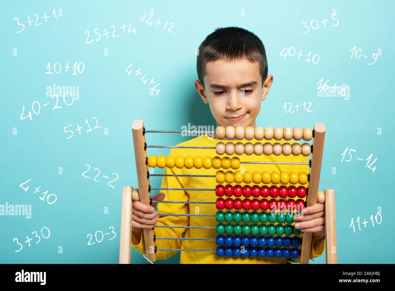 Child tries to solve mathematical problem with abacus. Cyan background Stock Photo