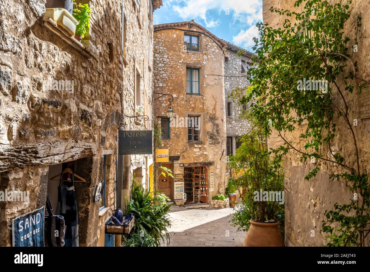 Small shops on an ancient street inside the medieval walled stone village of Tourrettes Sur Loup in the Provence Alpes Maritimes area of South France. Stock Photo
